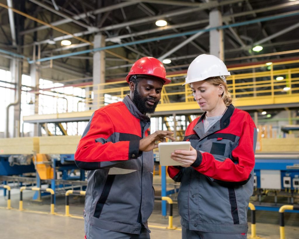 Manufacturing professionals reviewing field service data on a factory floor